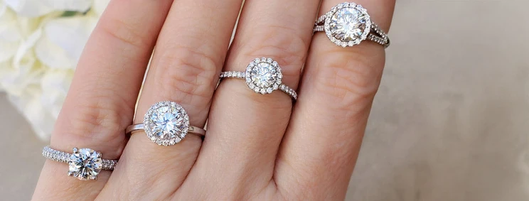 Platinum Pavé Halo Diamond Engagement Rings on each finger of a model's hand