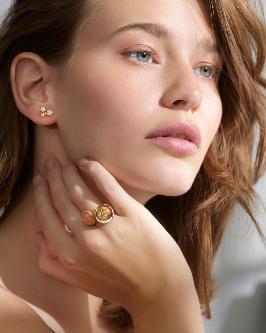Brunette model wearing Lotus rings and Shooting Star Triple Stud Earring