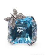 A large gemstone statement ring for nature lovers! This delightful butterfly ring by Adolfo Courrier feature an 18k white gold and pave diamond encrusted butterfly perched upon an incredible lucid blue topaz "pond." The sculpted shank of this decadent statement ring is studded with blue sapphires to bring added sparkle to the finger.⁠
⁠